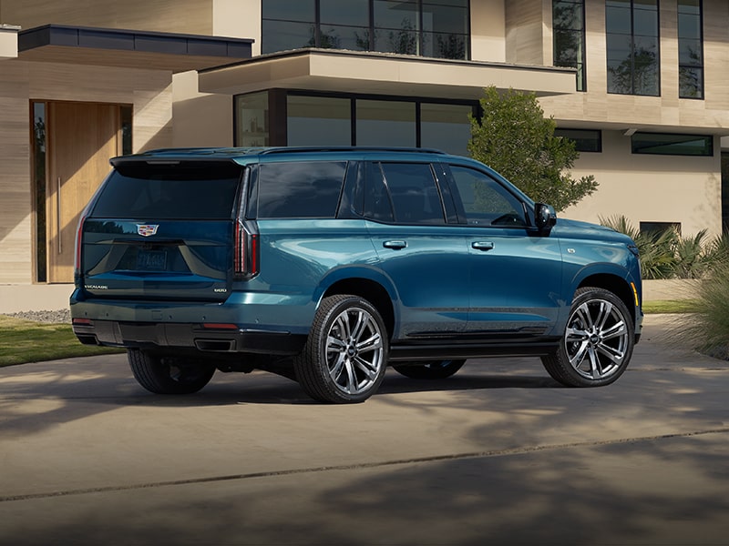 Blue Cadillac Escalade outside a modern home